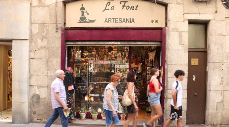 Un grup de persones passant per davant d'una botiga al carrer Ballesteries de Girona. ACN
