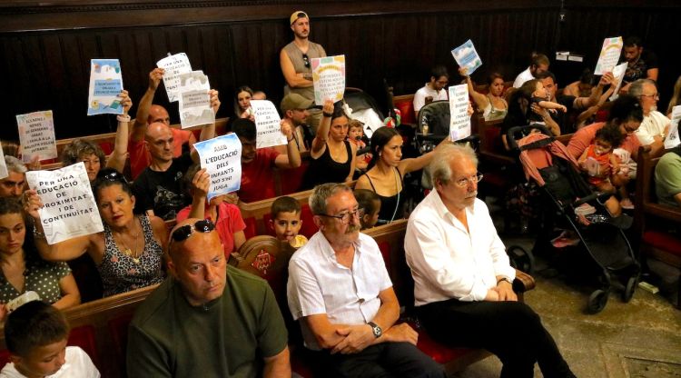 Les famílies afectades per la reducció de línies d'I1 a l'escola bressol La Baldufa, protestant al ple. ACN