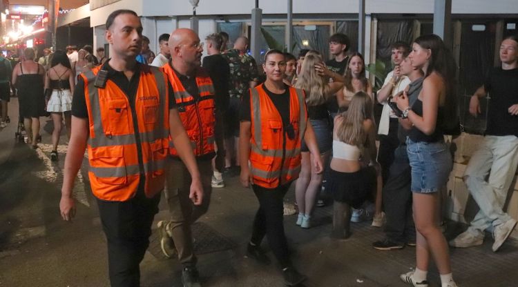 Dos auxiliars nocturns i el coordinador passegen per un carrer de Lloret controlant que la gent no faci soroll o begui alcohol a la via pública. ACN
