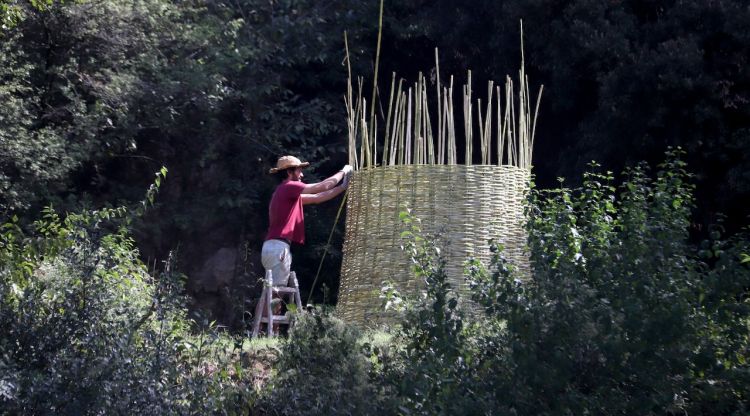 L'artista Nil Nebot treballa en un dels muntatges del festival Art&Gavarres. ACN