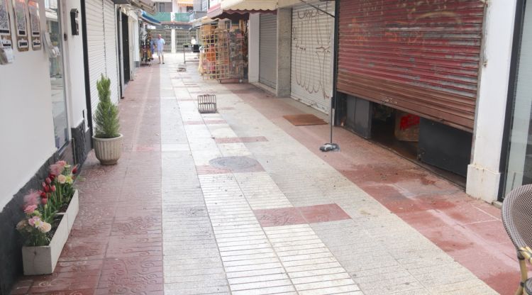 Un carrer d'una galeria de Platja d'Aro amb els embornals aixecats i restes de fulles després de l'aiguat. ACN
