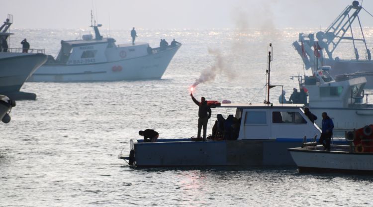 Un pescador amb una bangala encesa en una de les barques a Blanes. ACN