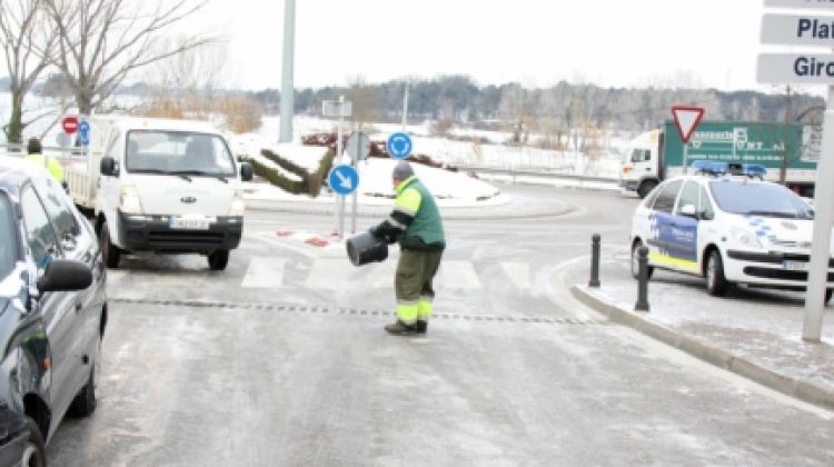 Brigades municipals i voluntaris escampant sal per fondre el gel © ACN