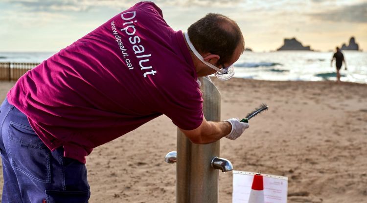 Un tècnic del Dipsalut portant a terme el control preventiu per evitar la legionel·la en un dels rentapeus d'una platja de la Costa Brava