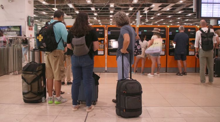 Persones esperant per utilitzar una màquina de venda de bitllets a l'estació de Sants. ACN