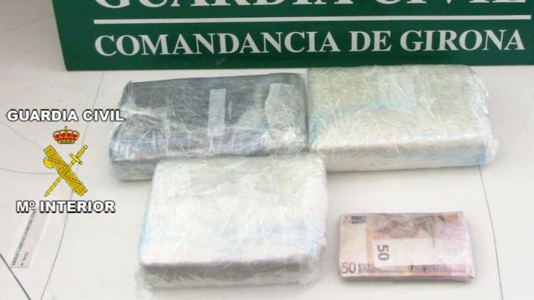 Els tres paquets intervinguts de droga i els 3.800 euros en metàl·lic © ACN