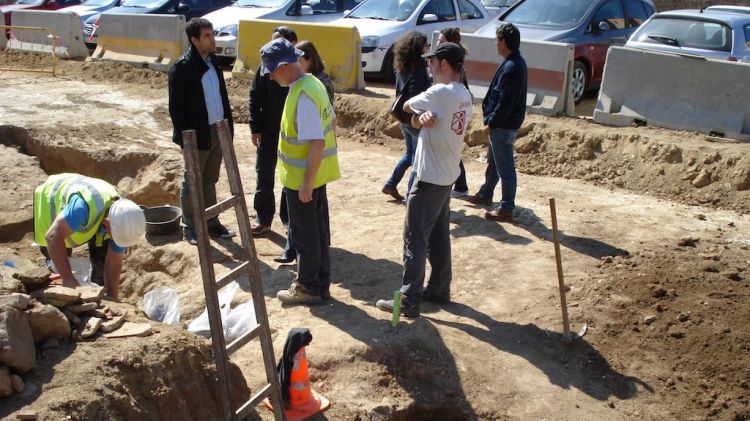 Tècnics municipals i de l'empresa que realitza la prospecció arqueològica, davant el forat de la sitja localitzada © ACN