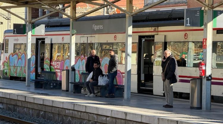 Un tren aturat a l'andana amb passatgers esperant a Figueres. ACN