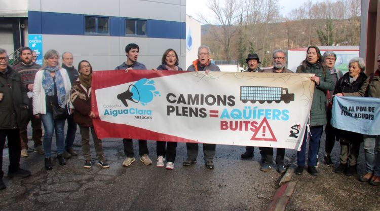 Representants dels ajuntaments que han subscrit la moció i entitats ecologistes protestant davant una planta embotelladora d'Arbúcies. ACN