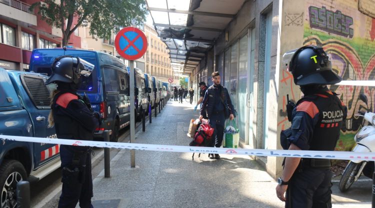 Un jove abandona l'edifici de la ronda Ferran Puig amb els Mossos. ACN