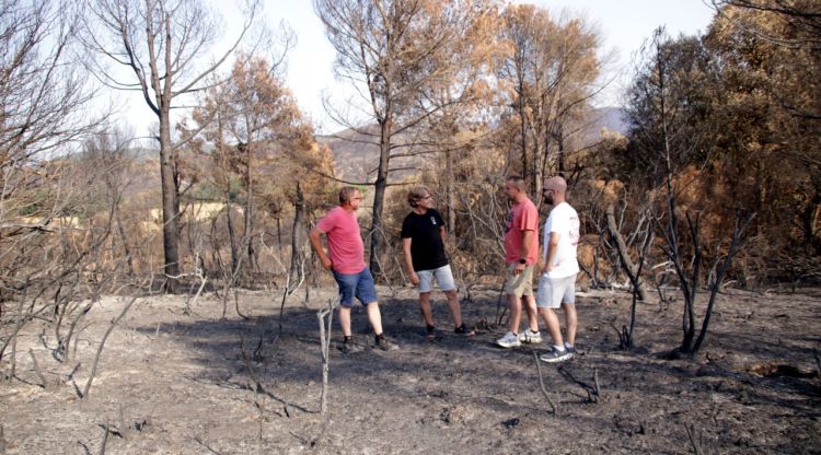 Quatre dels organitzadors de la 'Liada per les Gavarres' en una zona afectada pel foc. ACN