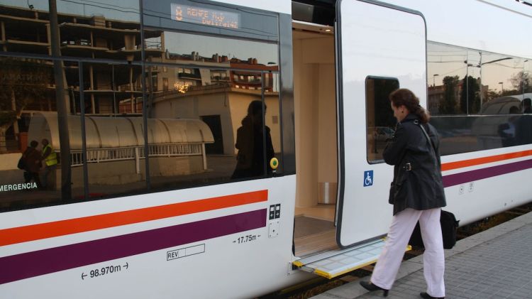 Una usuària a punt d'entrar a un tren regional de Renfe a Girona © ACN