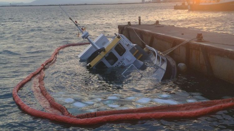 L'embarcació reflotada parcialment amb globus d'aire al port de Roses © ACN