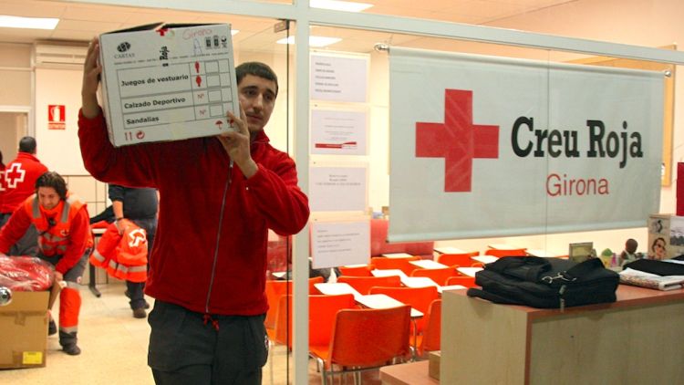 Un voluntari de la Creu Roja traslladant el material per carregar els vehicles © ACN