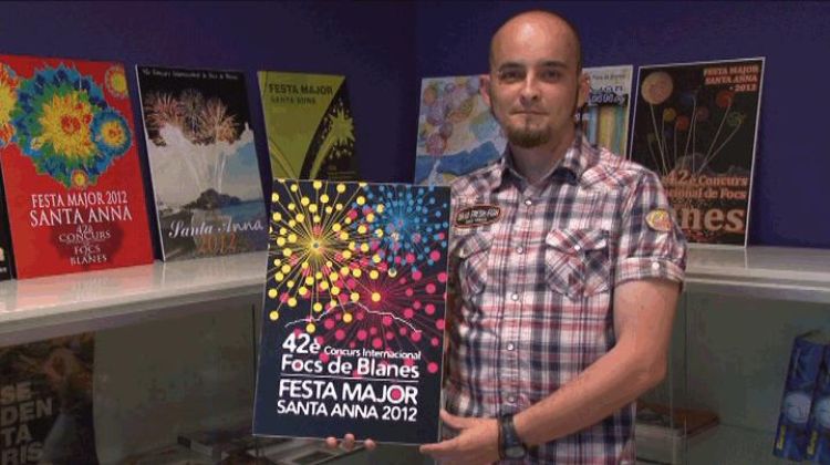 L'autor, Dani Puentes, al costat del cartell guanyador © AG