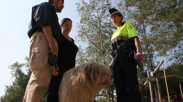 Un agent informant sobre les ordenançes als proietaris d'un gos (arxiu)