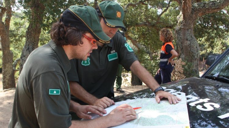 Els Agents Rurals miren els mapes que indiquen els límits del massís de Cadiretes © ACN