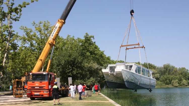 Una grua de grans dimensions ha tornat a posar la barca de passeig de l'Estany a l'aigua © ACN