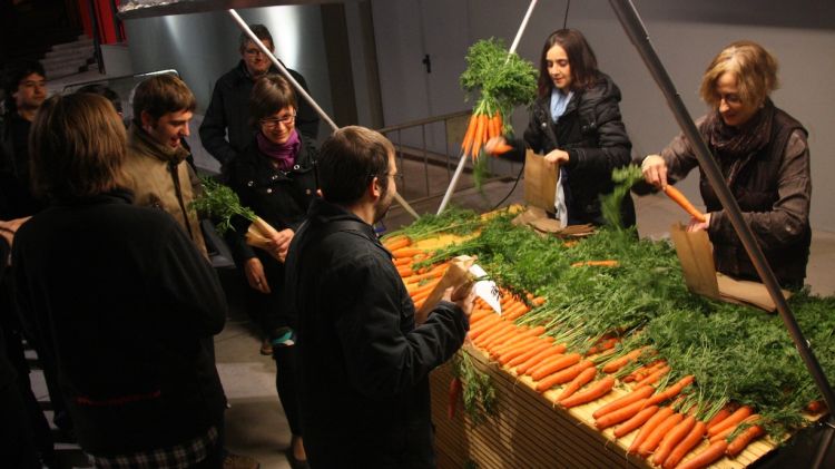 Diversos assistents a l'obra 'Suïcides' al Teatre de Bescanó recollint la seva pastanaga © ACN
