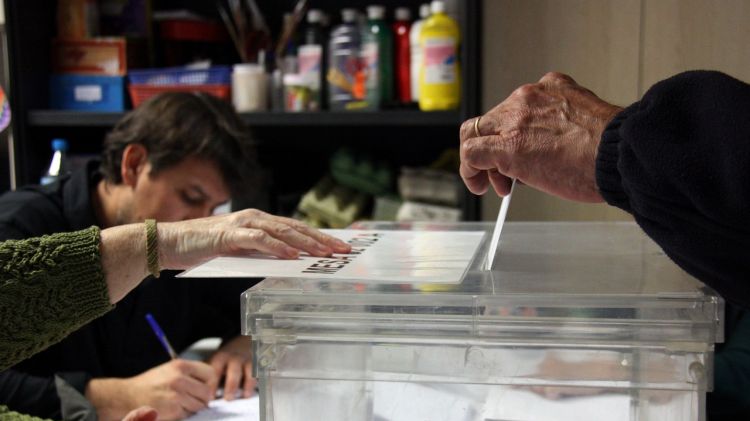 Una electora introdueix el sobre a l'urna © ACN