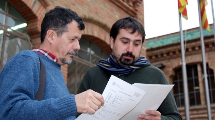 L'alcalde de Celrà, Dani Cornellà, i el tinent d'alcalde, Gerard Fernández, mirant la denúncia © ACN