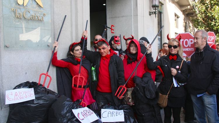 Membres de la PAH de Girona amb carbó a l'exterior d'una oficina de 'La Caixa' a Girona © ACN