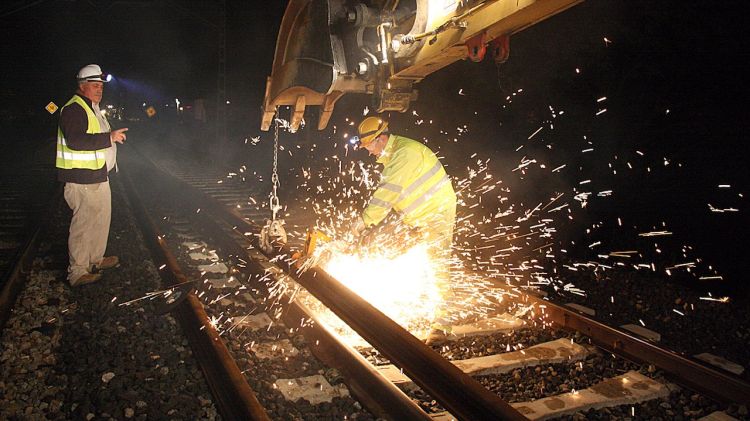 Operaris tallant el rail d'acer per soldar-lo i continuar l'estesa del tercer rail © ACN