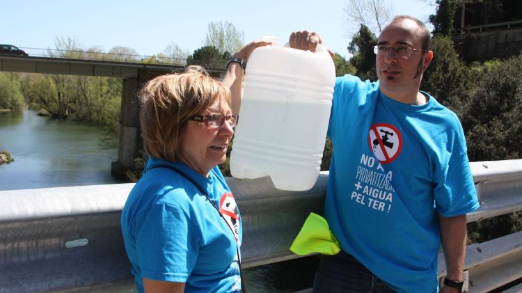 Dos membres de la Plataforma Aigua és Vida a punt de tirar l'aigua © ACN