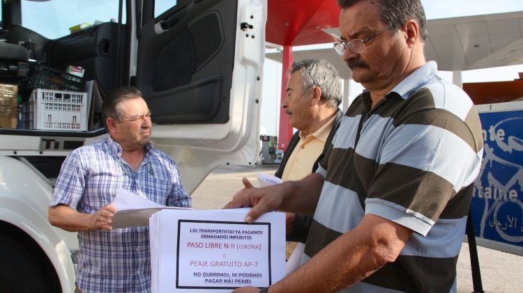 Representants de les patronals de transportistes informen a un camioner de la seva protesta © ACN