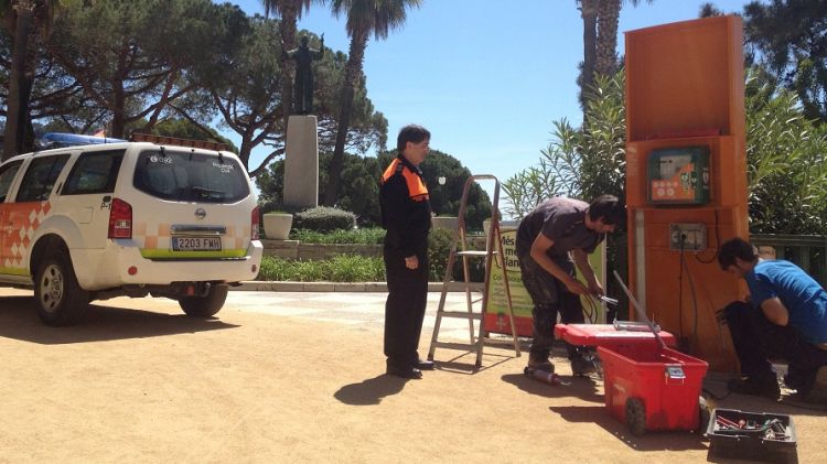 Operaris instal·lant un desfibril·lador al Passeig Marítim