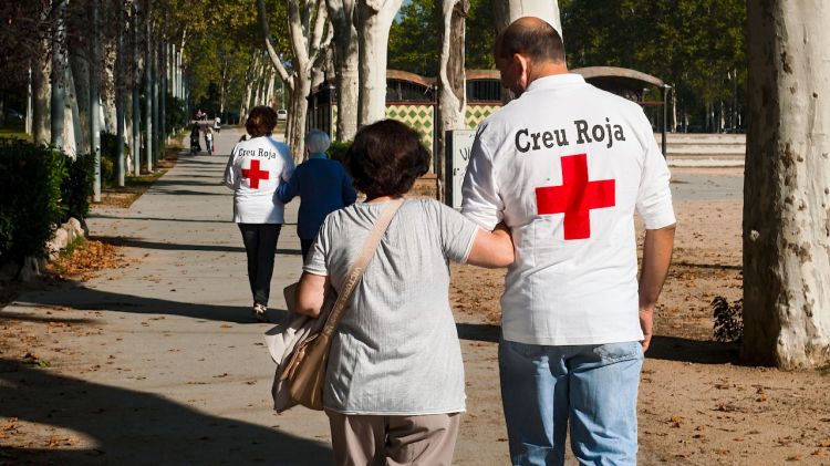 Voluntaris de la Creu Roja fent un acompanyament a persones grans © ACN