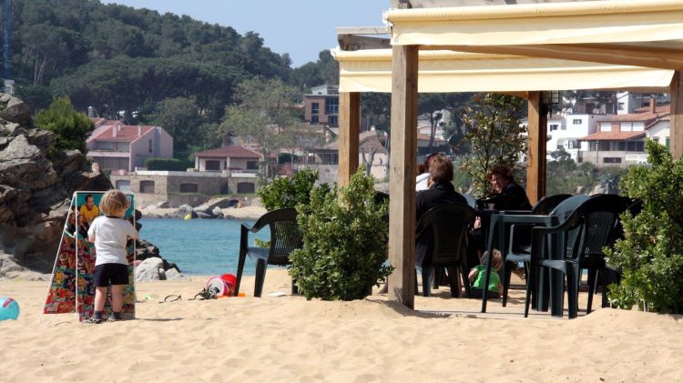 Turistes prenent el sol a una guingueta de platja a la Fosca © ACN