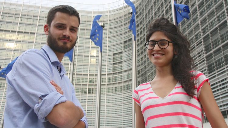 L'Albert Sesé i la Marta Pont davant de les banderes europees de l'edifici de la Comissió Europea a Brussel·les © ACN