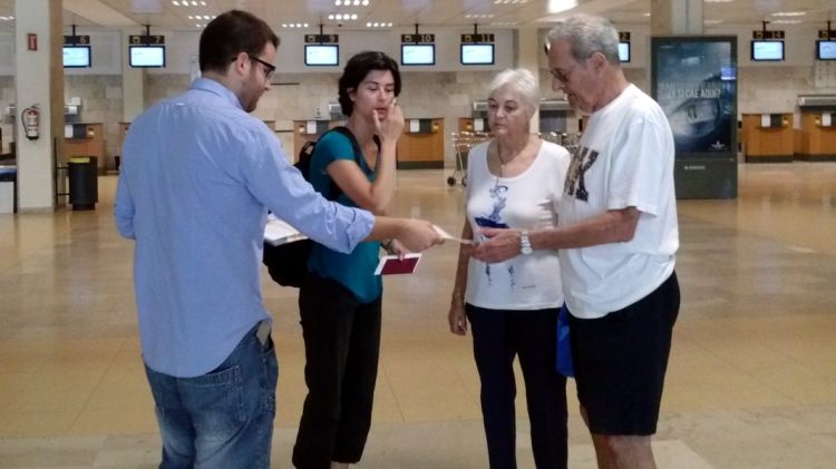 Imatge d'un membre de la JNC repartint fulletons ahir diumenge a l'aeroport de Girona © ACN