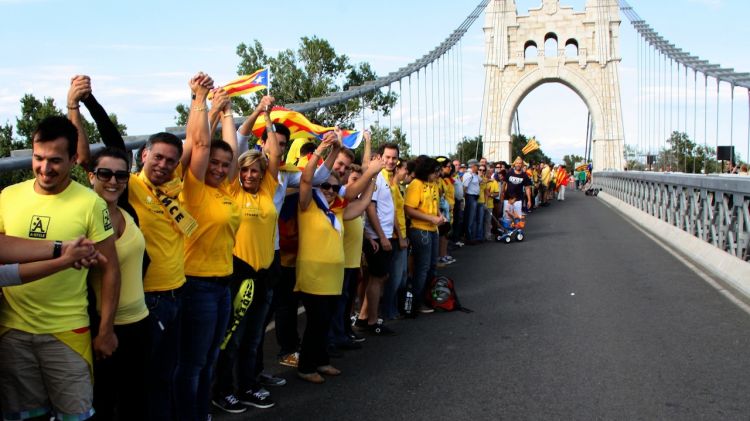 Els participants a la cadena humana enllacen les seves mans sobre el pont penjant d'Amposta © ACN