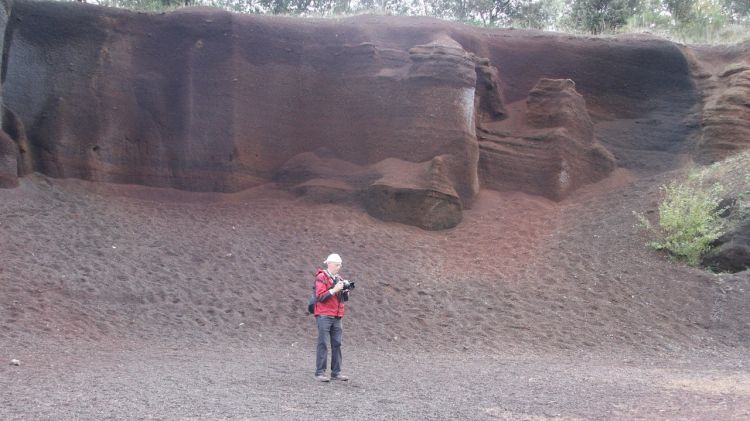 Un visitant al Croscat en una de les parets on hi ha una pintada feta rascant amb la mà a la paret © ACN