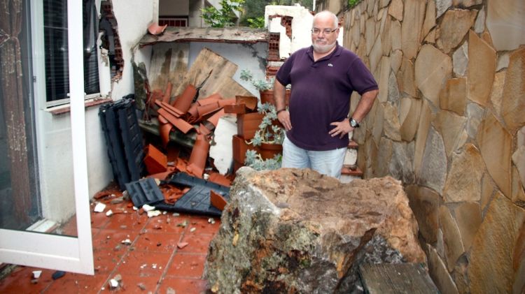 En Ricard, propietari de l'habitatge, al costat de la roca que ahir li va caure al patí de casa © ACN