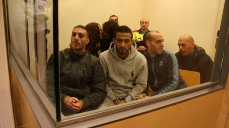 Els sis acusats seguint el judici des de la 'peixera' i custodiat pels Mossos d'Esquadra aquest divendres al matí © ACN