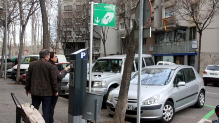Una parella paga a la zona verda de la Devesa-Güell, en el primer dia de funcionament de la nova modalitat d'aparcament.