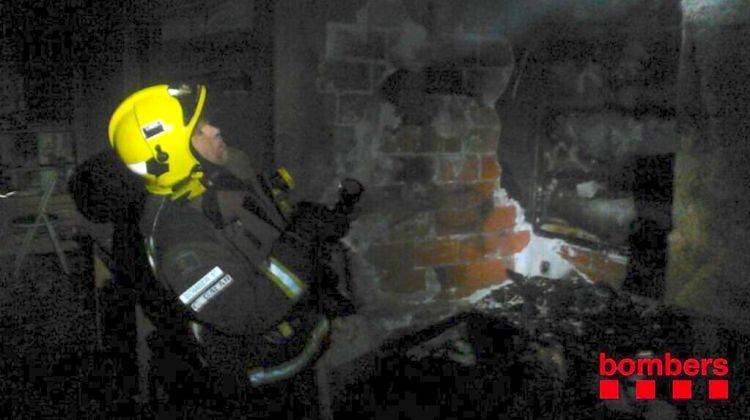 Un bomber en les tasques d'extinció del menjador cremat © Bombers