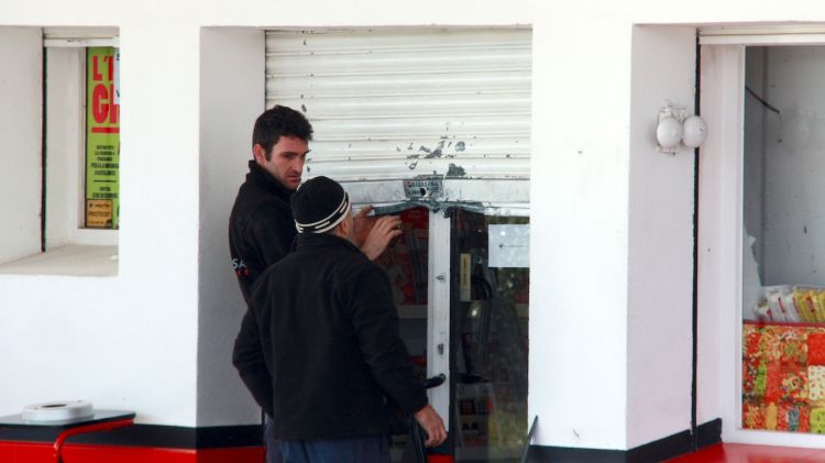 Dos operaris treballen en la porta que han forçat els lladres © ACN