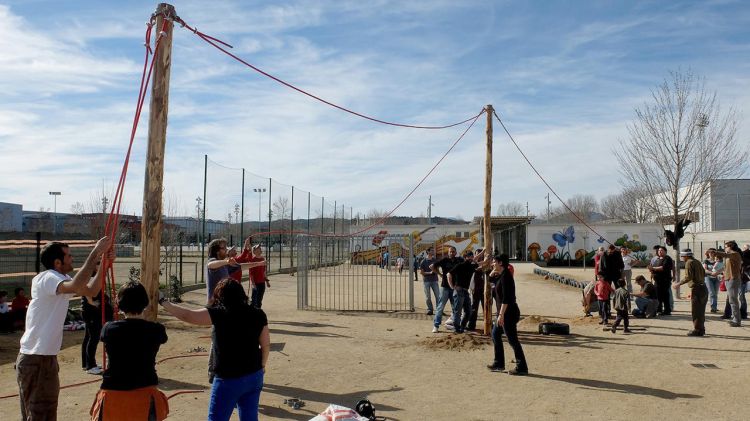 Pares de l'AMPA instal·lant uns pals on es col·locarà la vela al patí © ACN