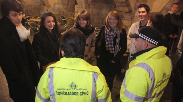 Dos dels conciliadors nocturns, la Marina i l'Emilio, parlen amb un grup de joves a la Rambla © ACN