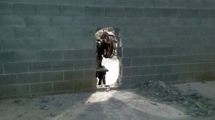 El forat que han fet els lladres a la paret de blocs de formigó de l'empresa Tordeco 1993 S.L © ACN