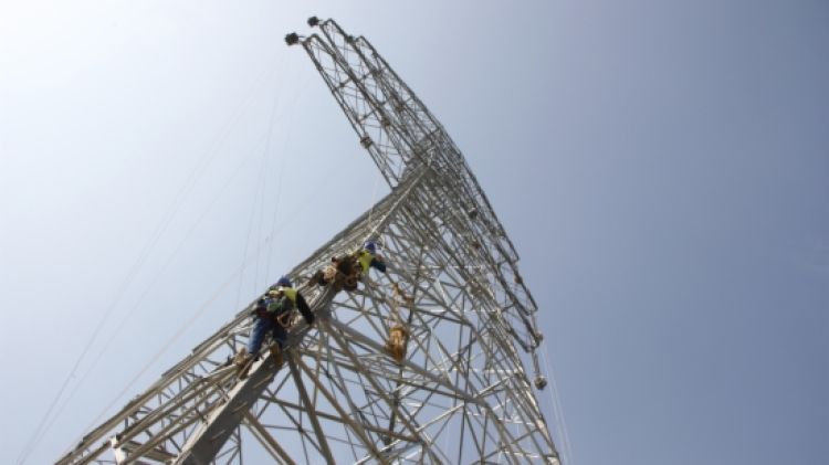 Dos tècnics de Red Eléctrica en una de les torres del tram de la MAT (arxiu) © ACN