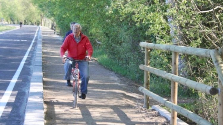 Dos ciclistes passant pel nou carril que s'ha construït a la carretera de l'Estany de Banyoles © ACN