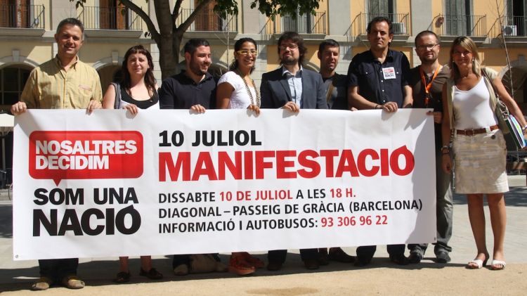 Membres d'Òmnium Gironès i dels sindicats amb el lema que encapçalarà la manifestació © ACN