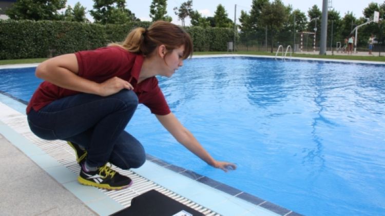 La tècnica agafant mostres de l'aigua de la piscina de Fornells de la Selva © ACN