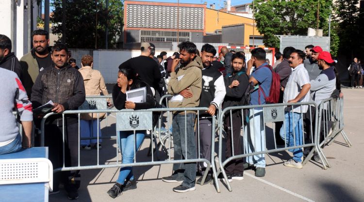 Cues de migrants a Salt per informar-se del procés de regularització extraordinària
